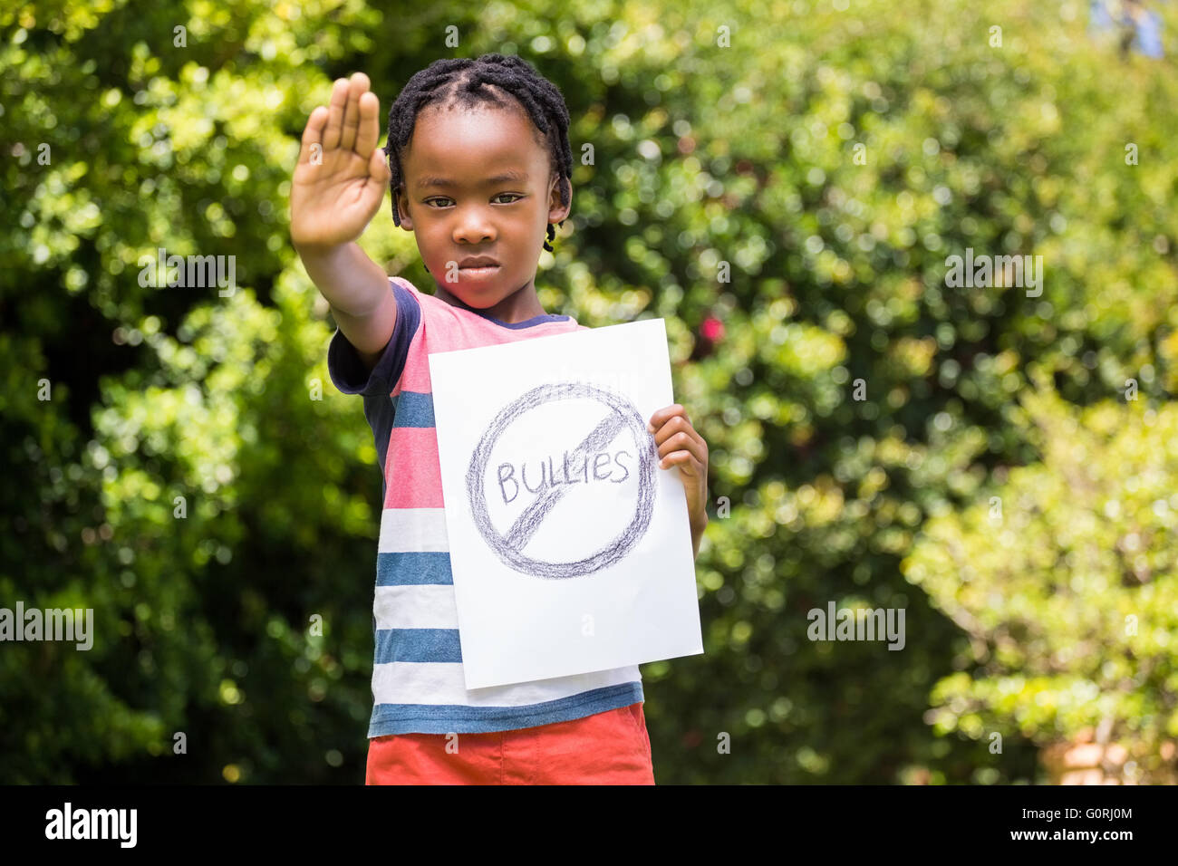 Boy saying stop with hand and paper Stock Photo