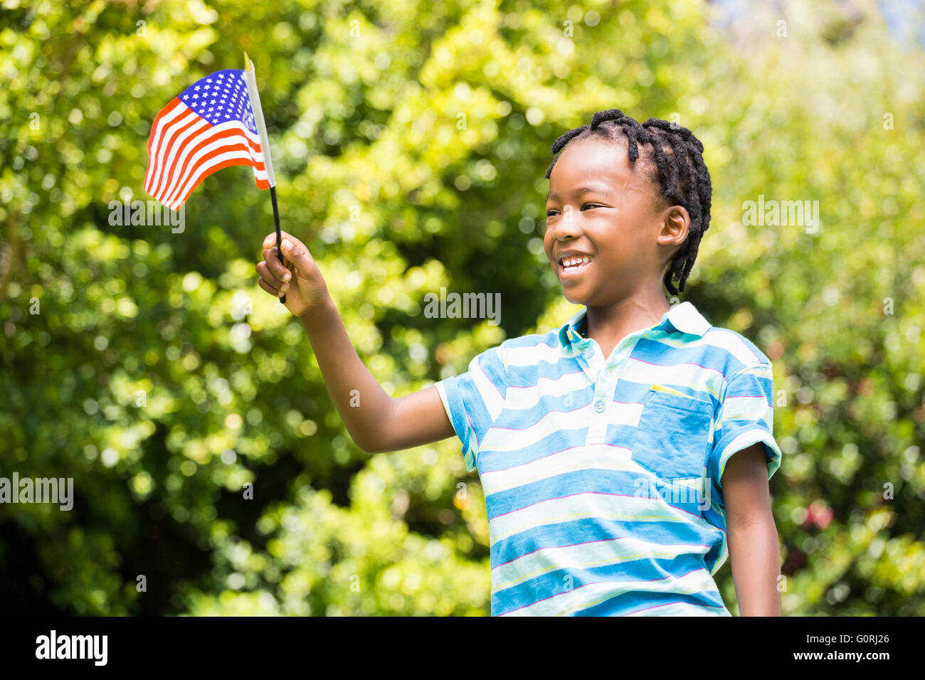 Smiling boy waving american flag Stock Photo