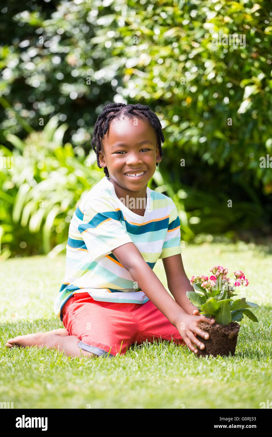 A boy sitting in the grass with plant Stock Photo