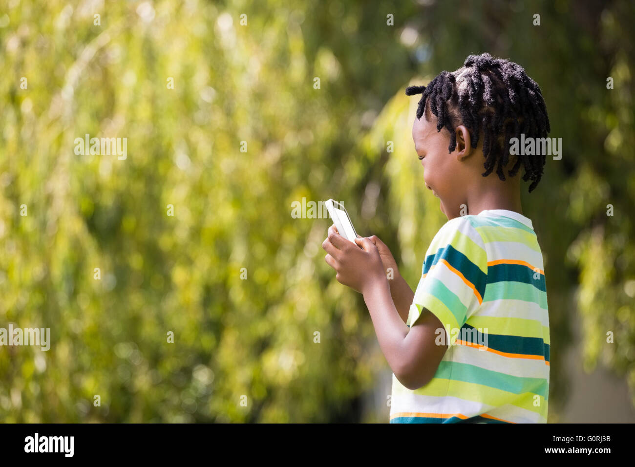 A kid playing with a mobile phone Stock Photo