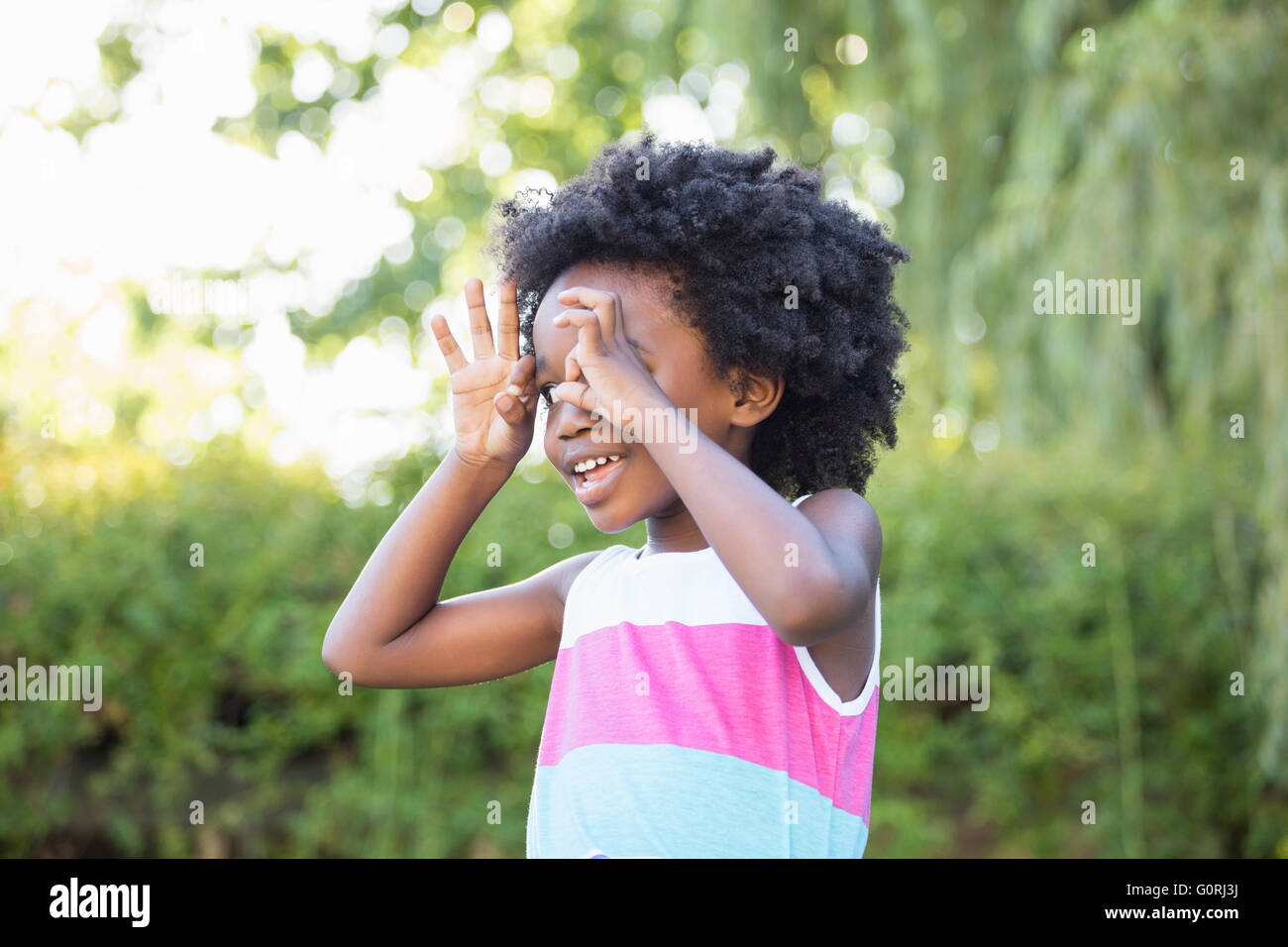 A kid putting her hands like glasses Stock Photo