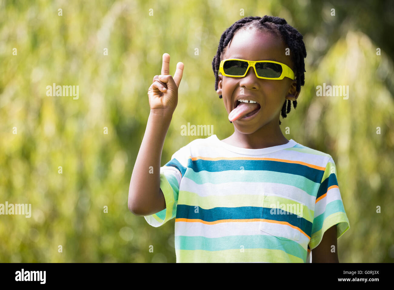 A kid with sunglasses making faces Stock Photo