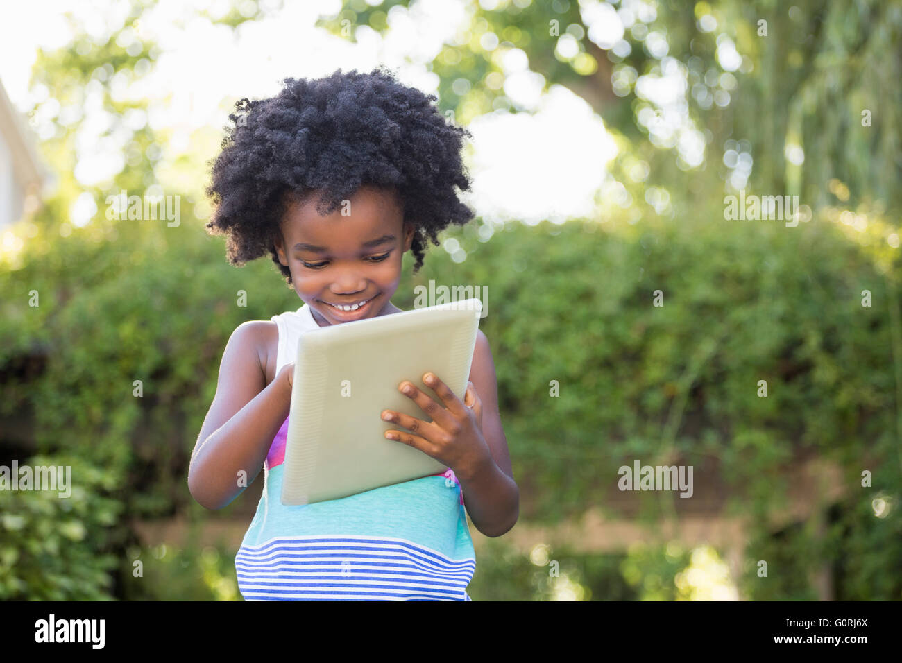 Cute boy smiling and using a tablet Stock Photo
