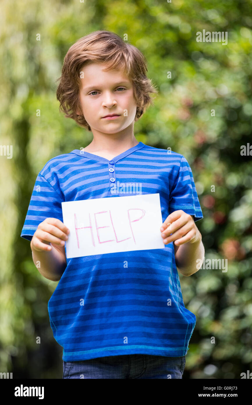 Serious boy holding a message and showing to the camera Stock Photo