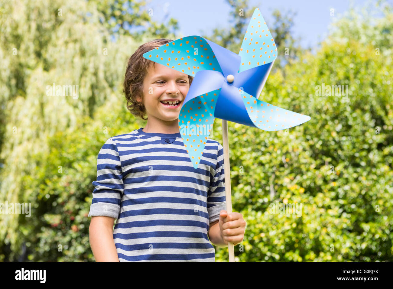 Windmill Boy Cute boy smiling and holding a windmill Stock Photo - Alamy