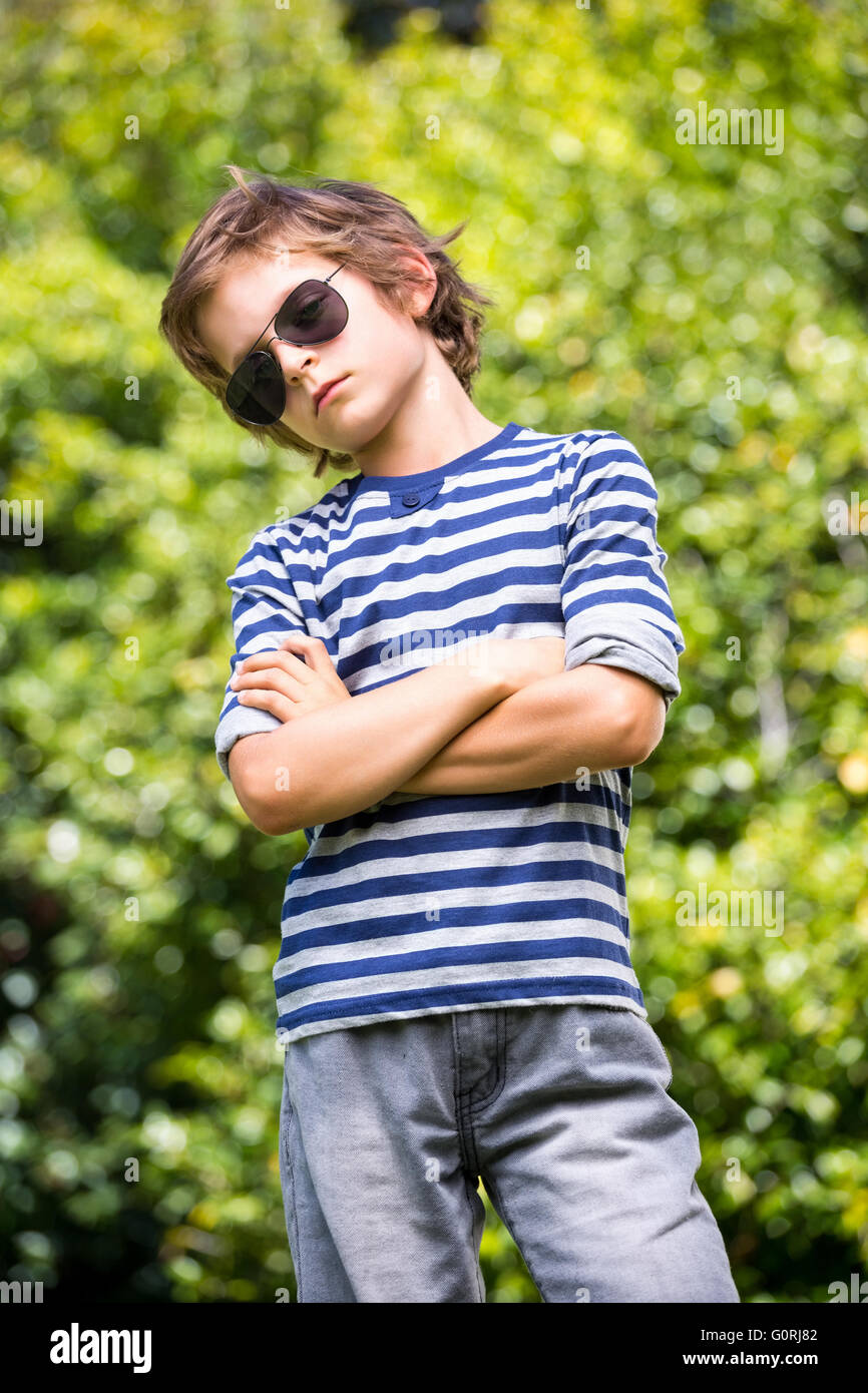 Cute boy with sunglasses posing with crossed arms Stock Photo