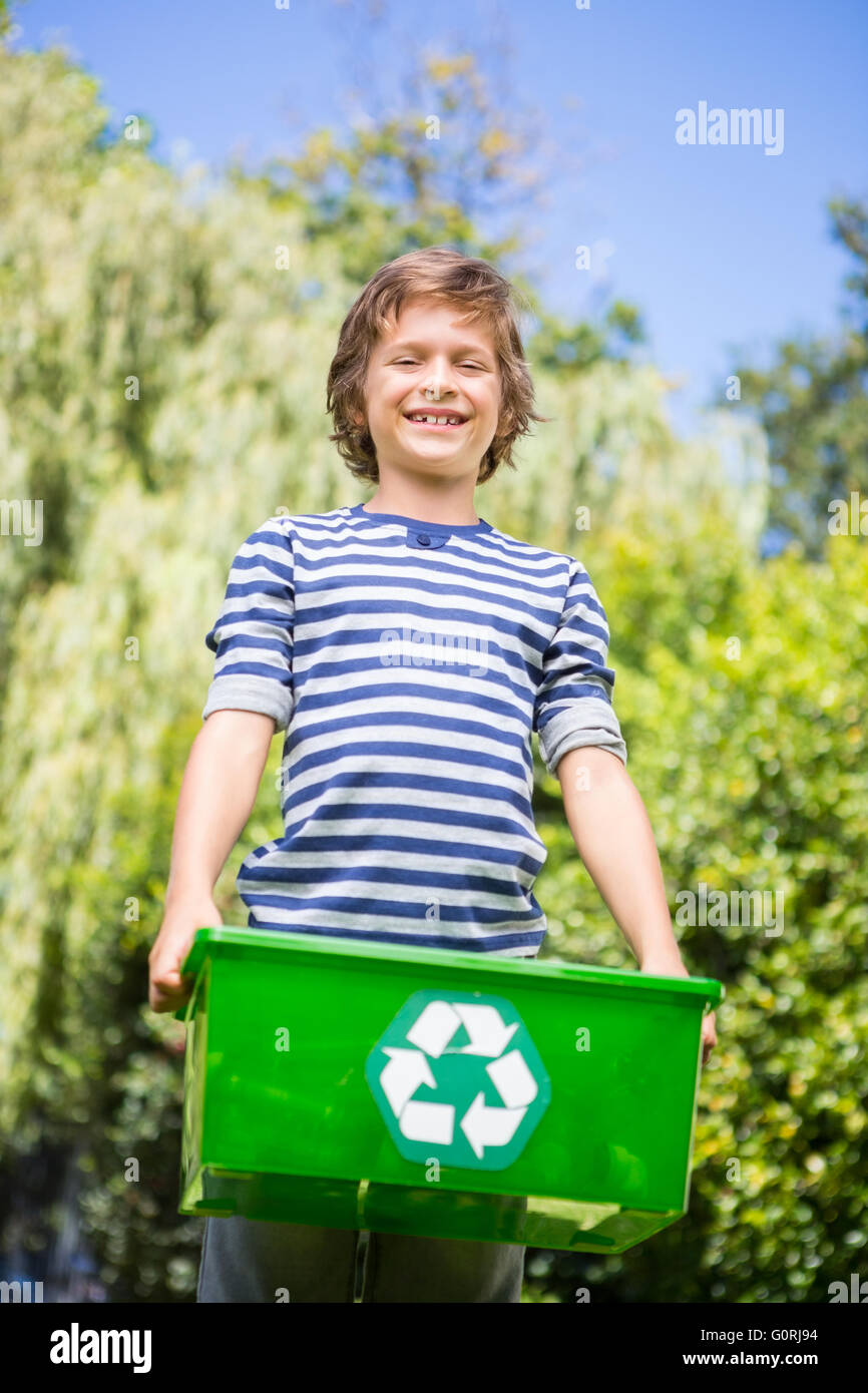 Low angle view of happy boy holding a recycling box Stock Photo