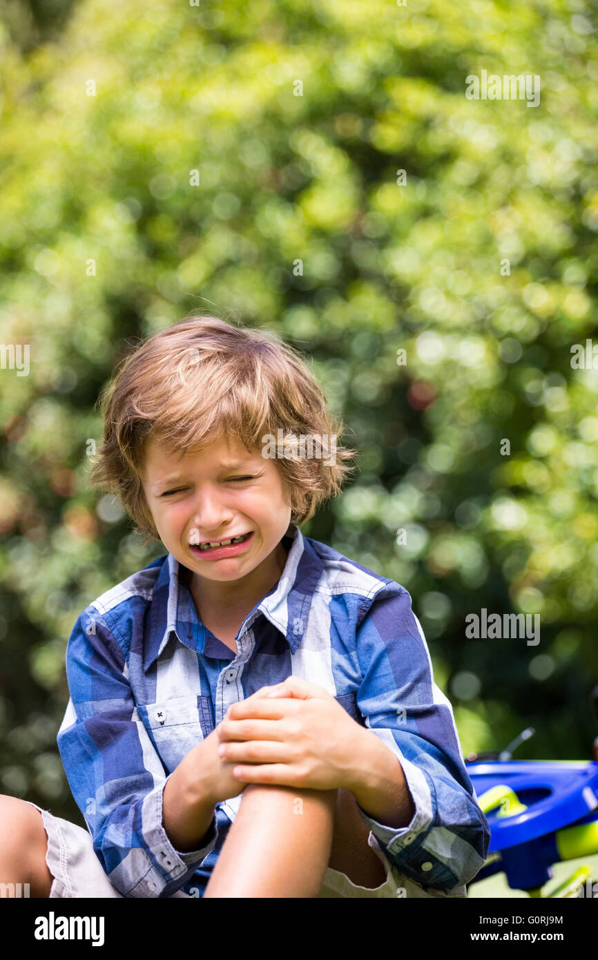 Portrait of cute boy crying cause of his bike fall Stock Photo