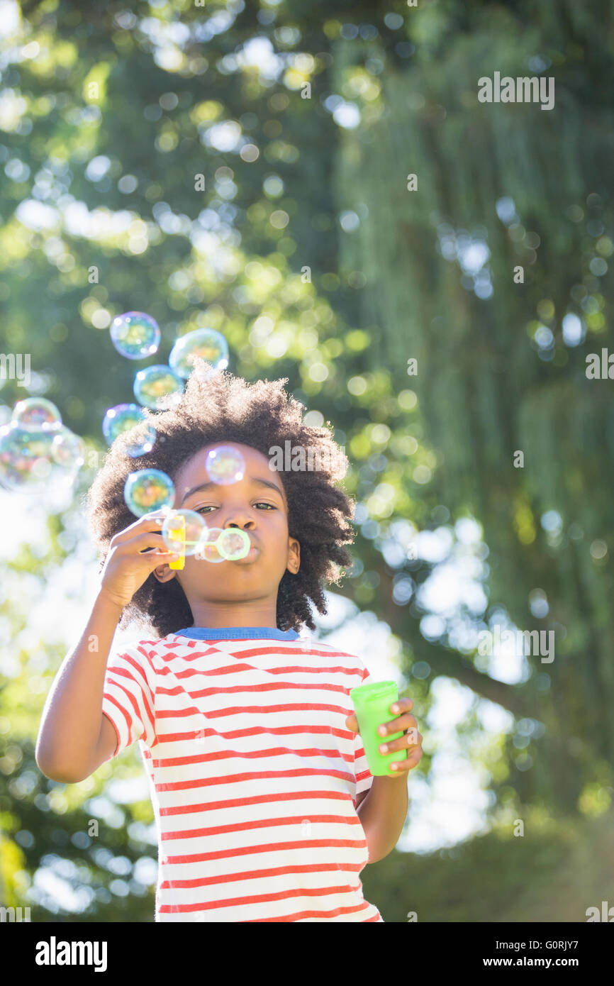 Portrait of boy making bubbles with bubble wand Stock Photo