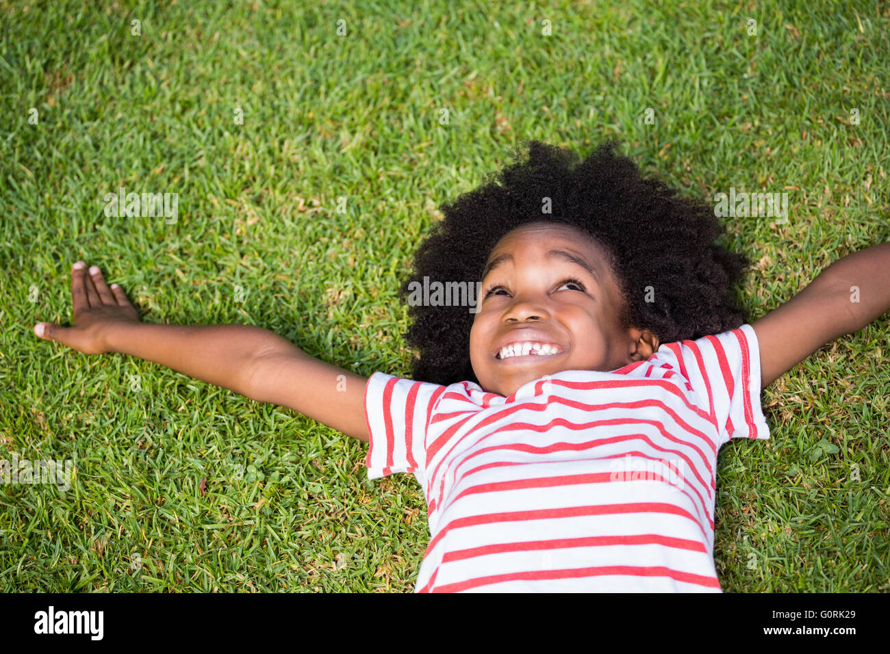 Smiling boy lying down in grass Stock Photo