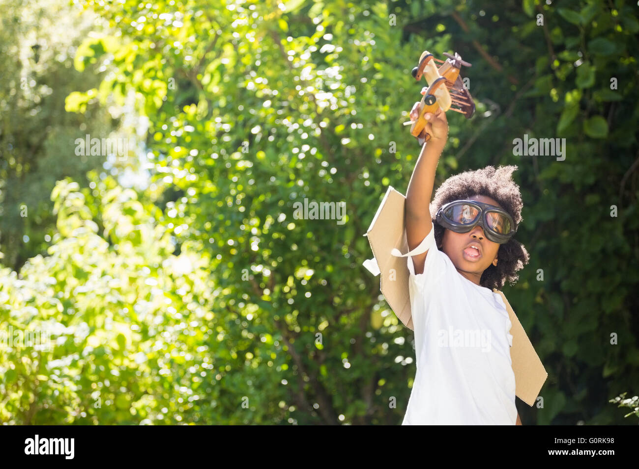 Boy playing with a toy plane at park Stock Photo