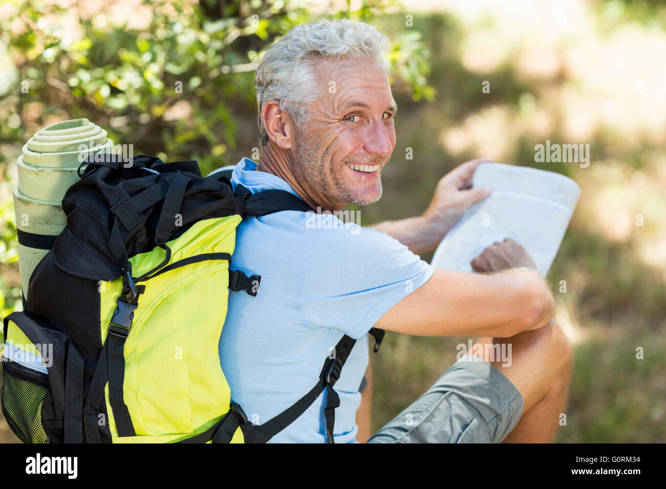 Hiker smiling and holding a map Stock Photo - Alamy