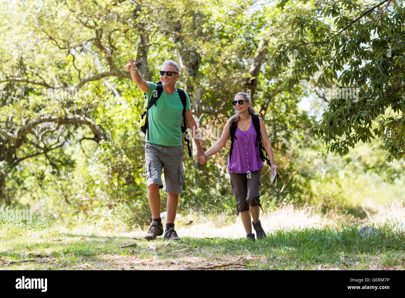 Couple pointing and holding hands each other during a hike Stock Photo