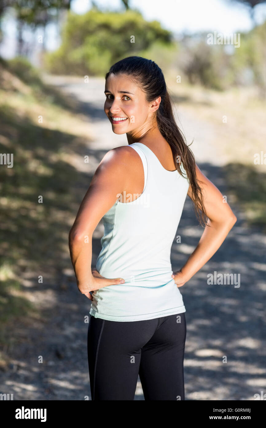 Woman runner front the back smiling and turning around to the camera Stock Photo