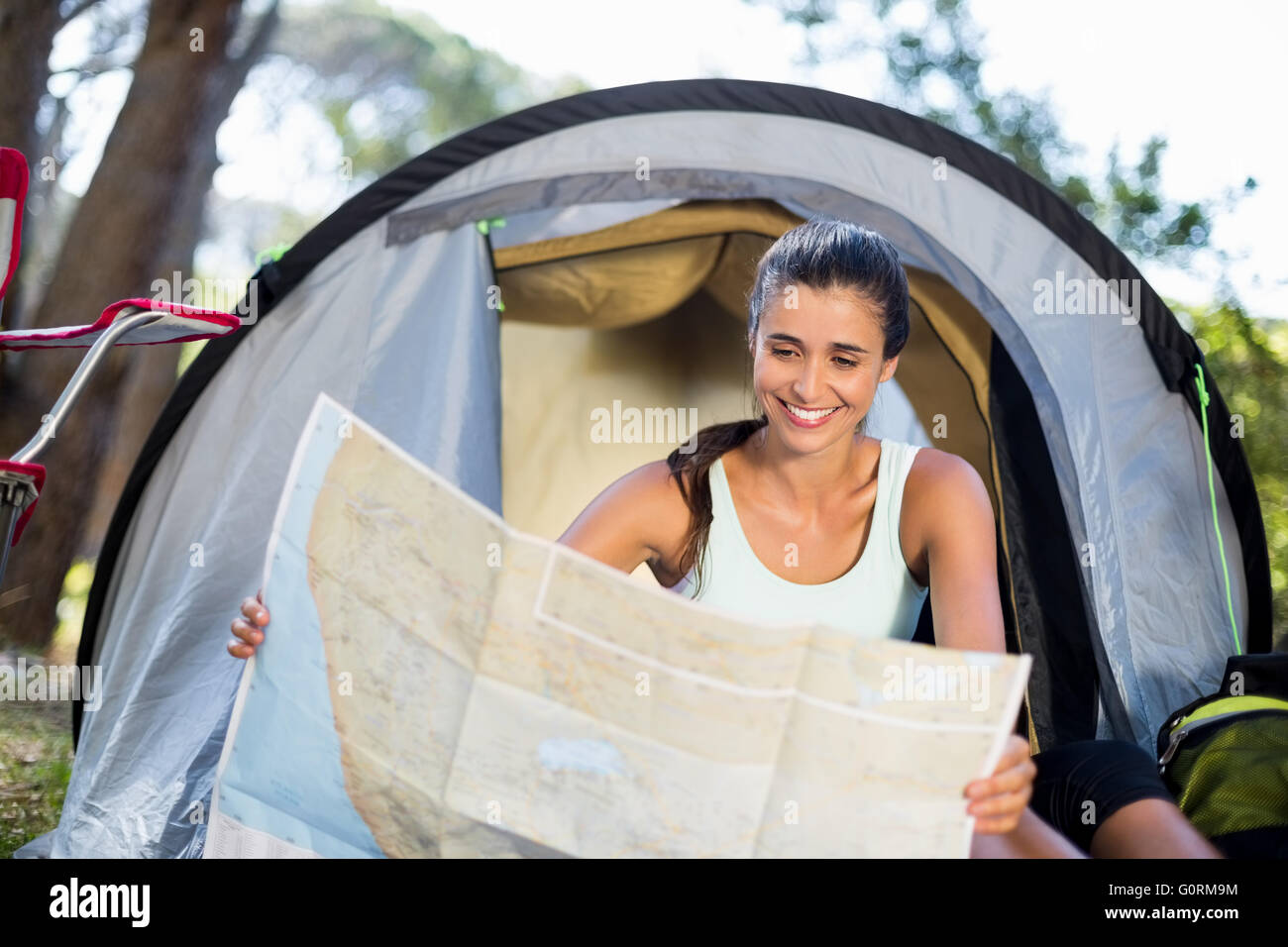 Woman smiling and studying a map Stock Photo - Alamy