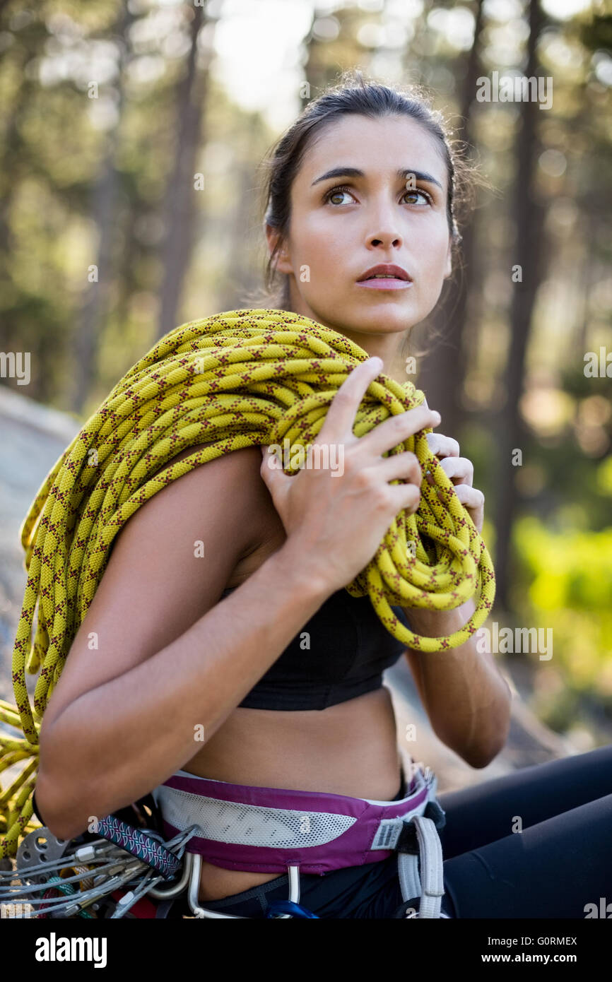 Portrait of woman sitting with climbing equipment Stock Photo