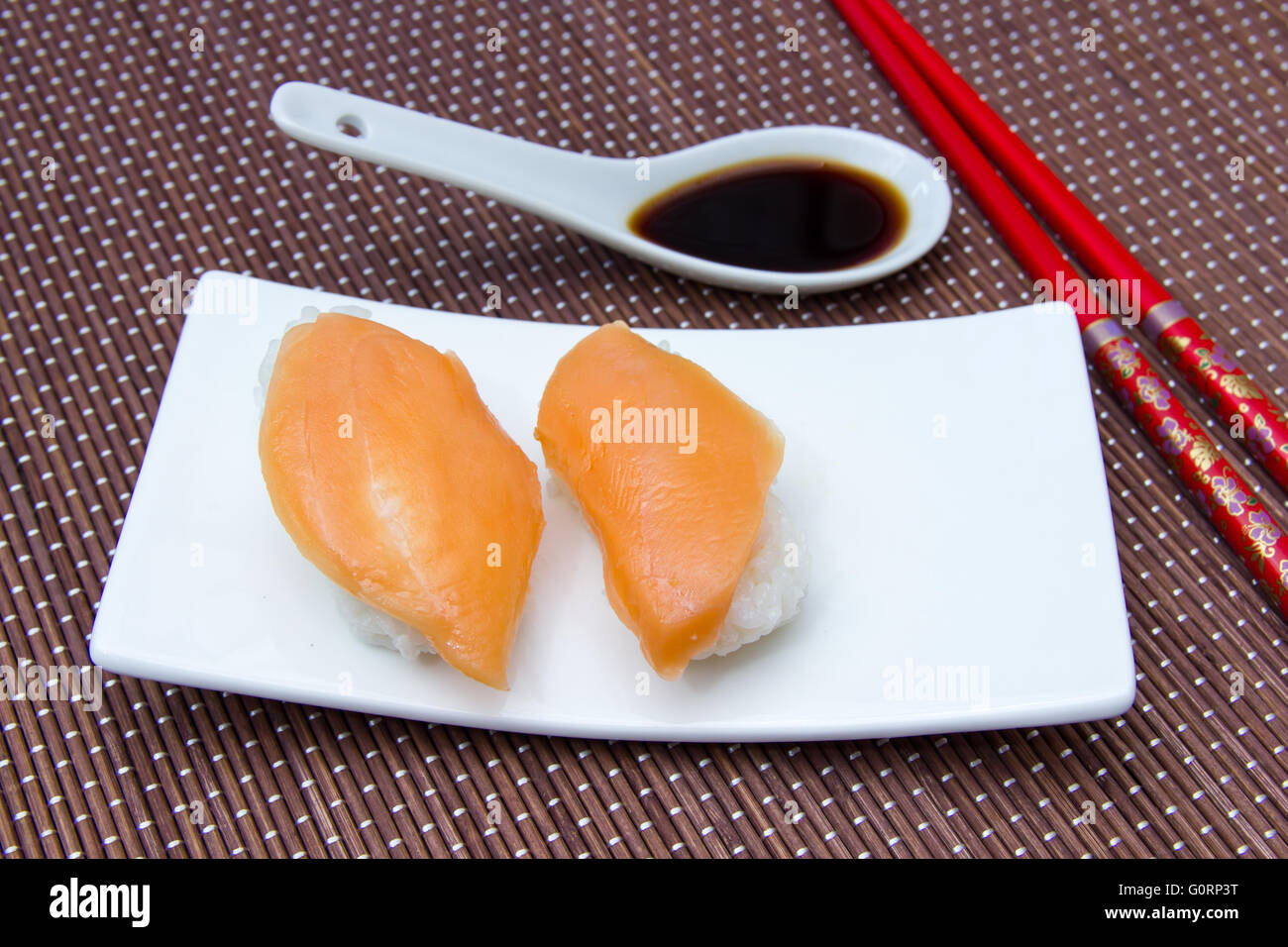 Nigiri with salmon on a placemat bamboo seen up close Stock Photo