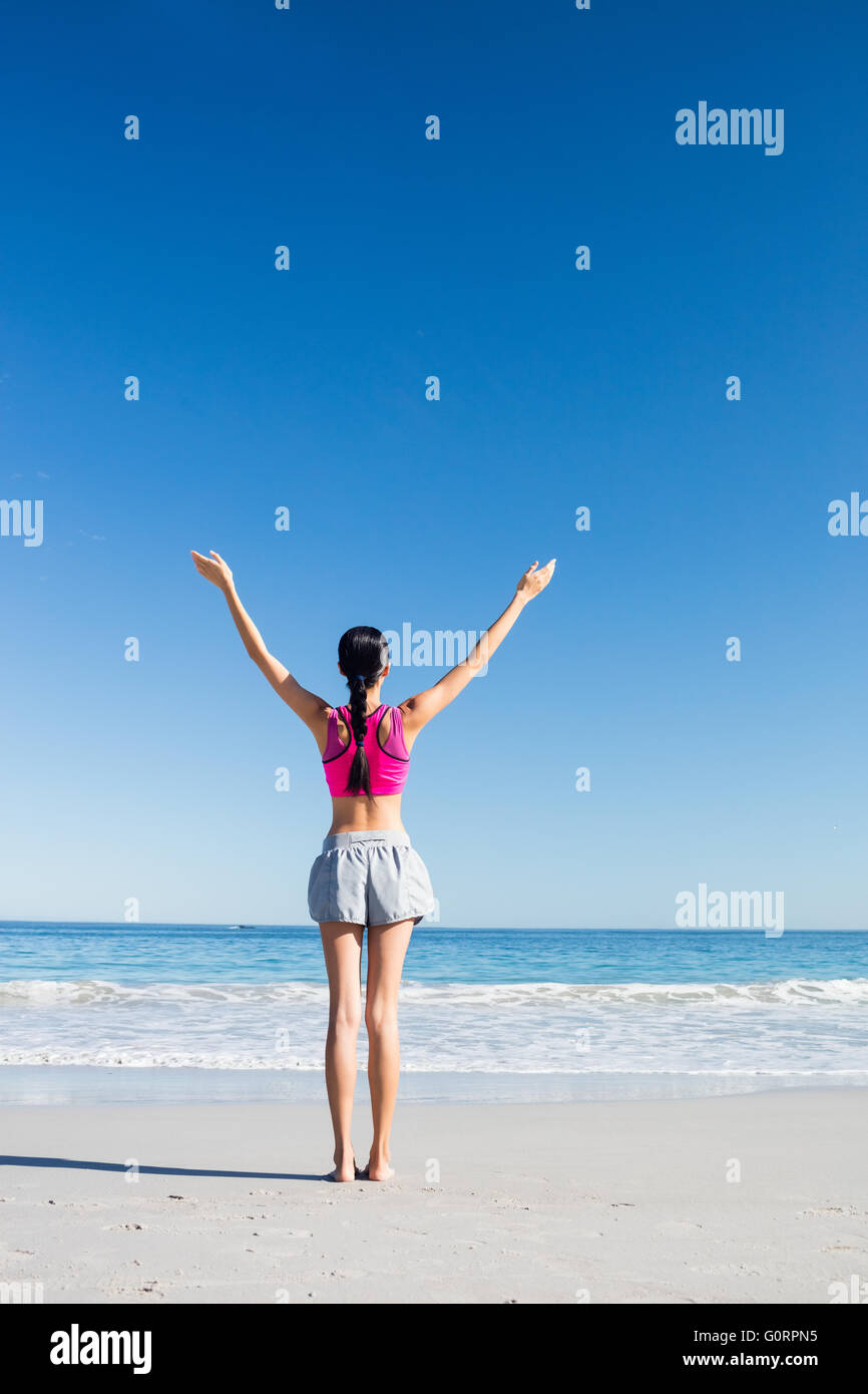 Woman with hands up on the beach Stock Photo - Alamy