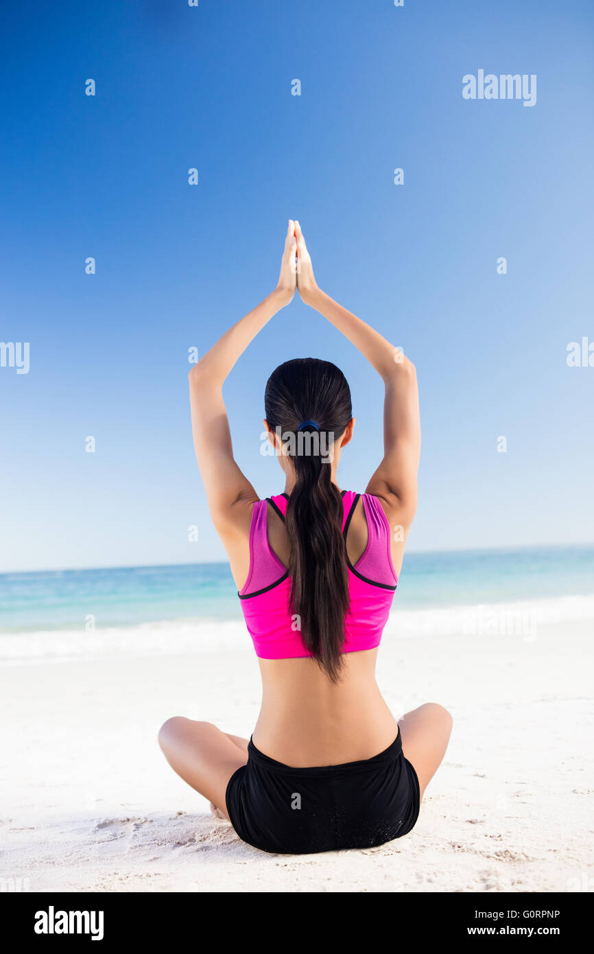 Woman doing yoga on the beach Stock Photo