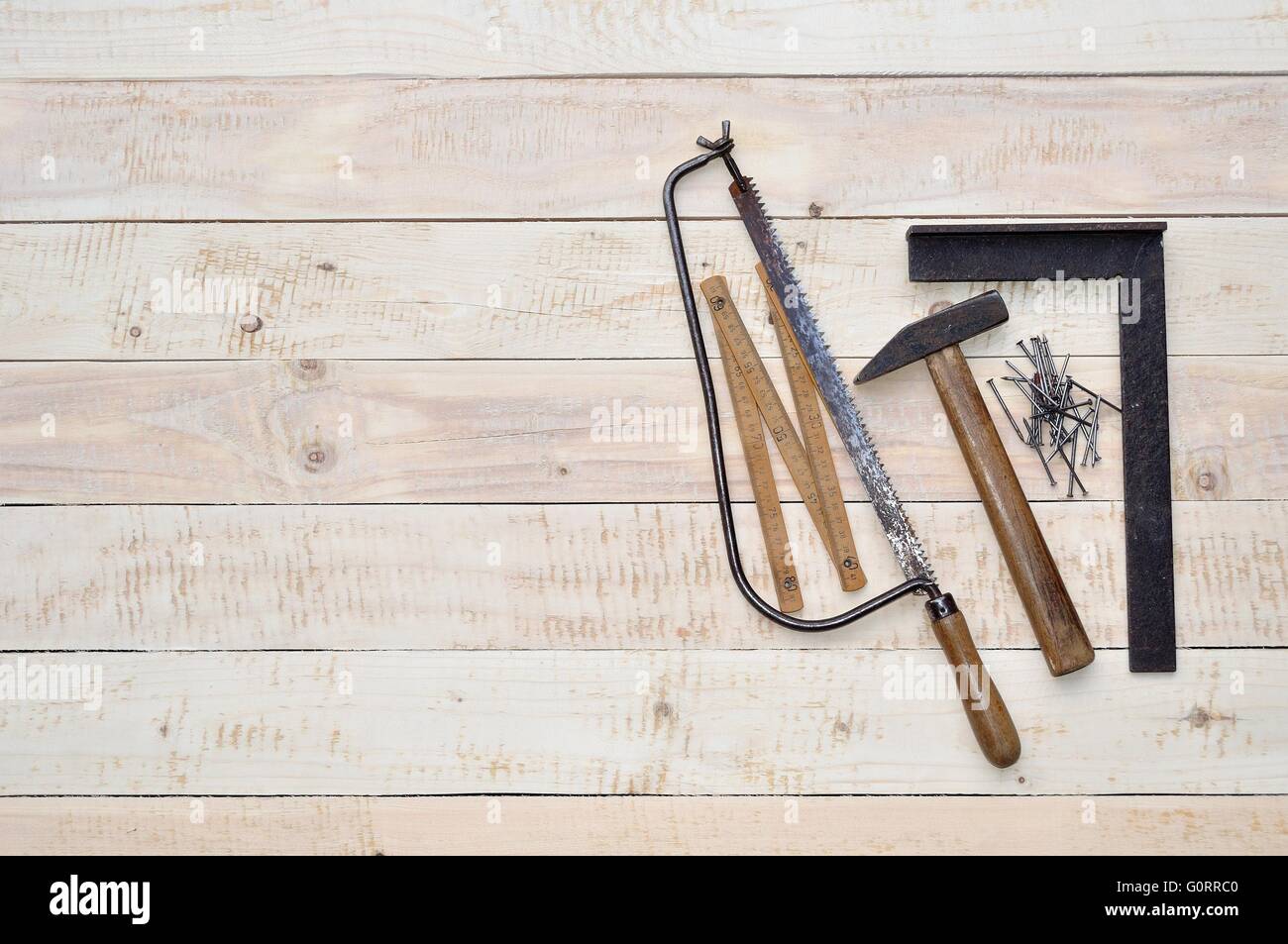 Carpenter tools - hammer, nails, tape measure and saw on wood. Space on ...