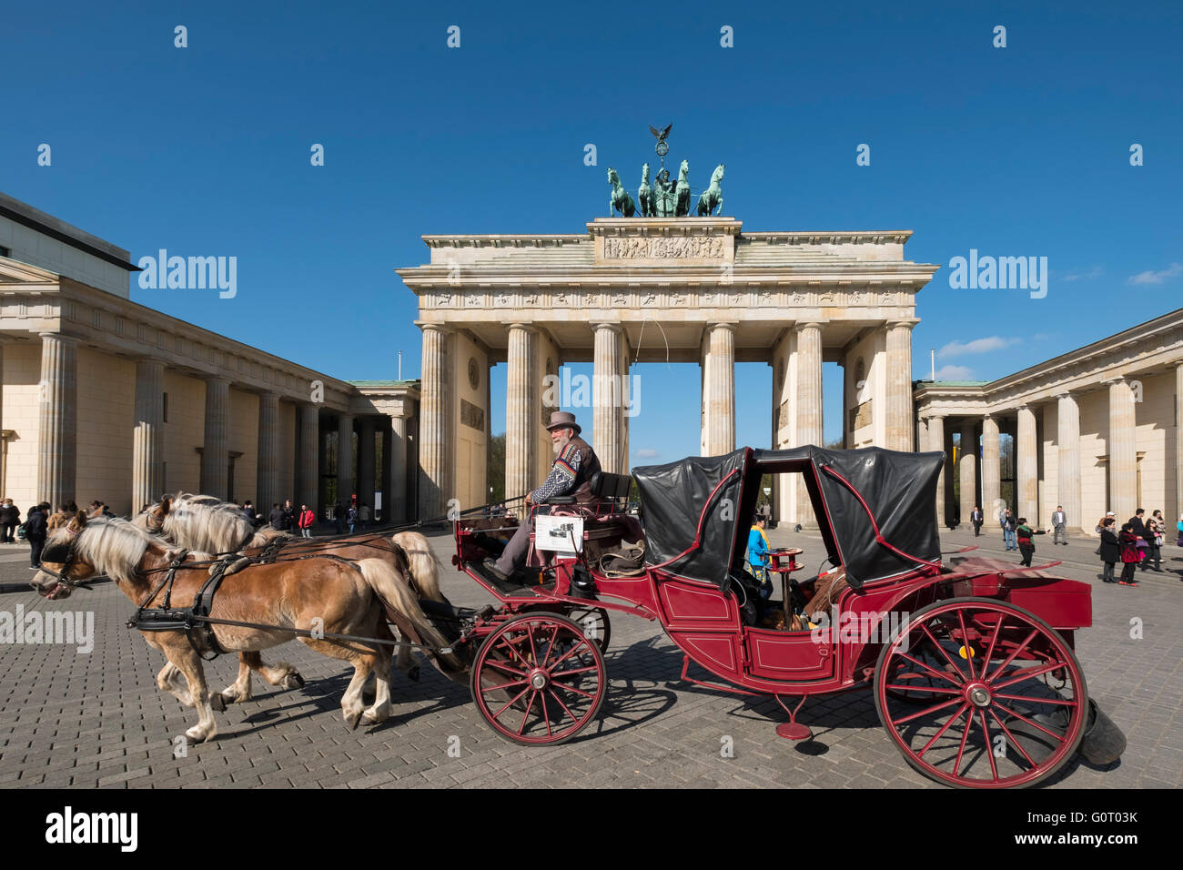Horsedrawn carriage passes in front of Brandenburg Gate in Berlin Germany Stock Photo