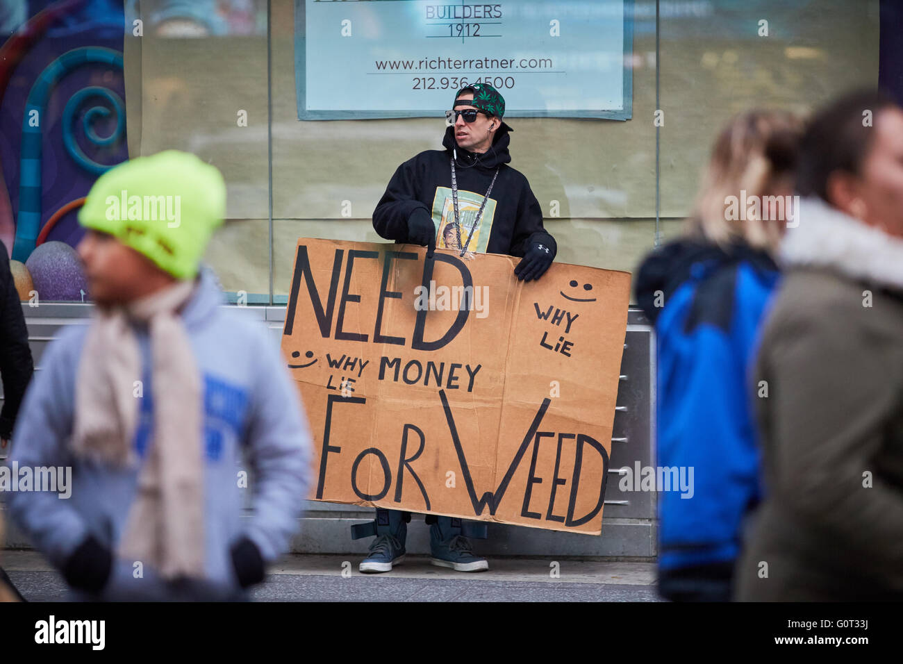 New York times Square   beggar begging wanting money cash hand looking for wanting humour homeless need money for weed sign card Stock Photo