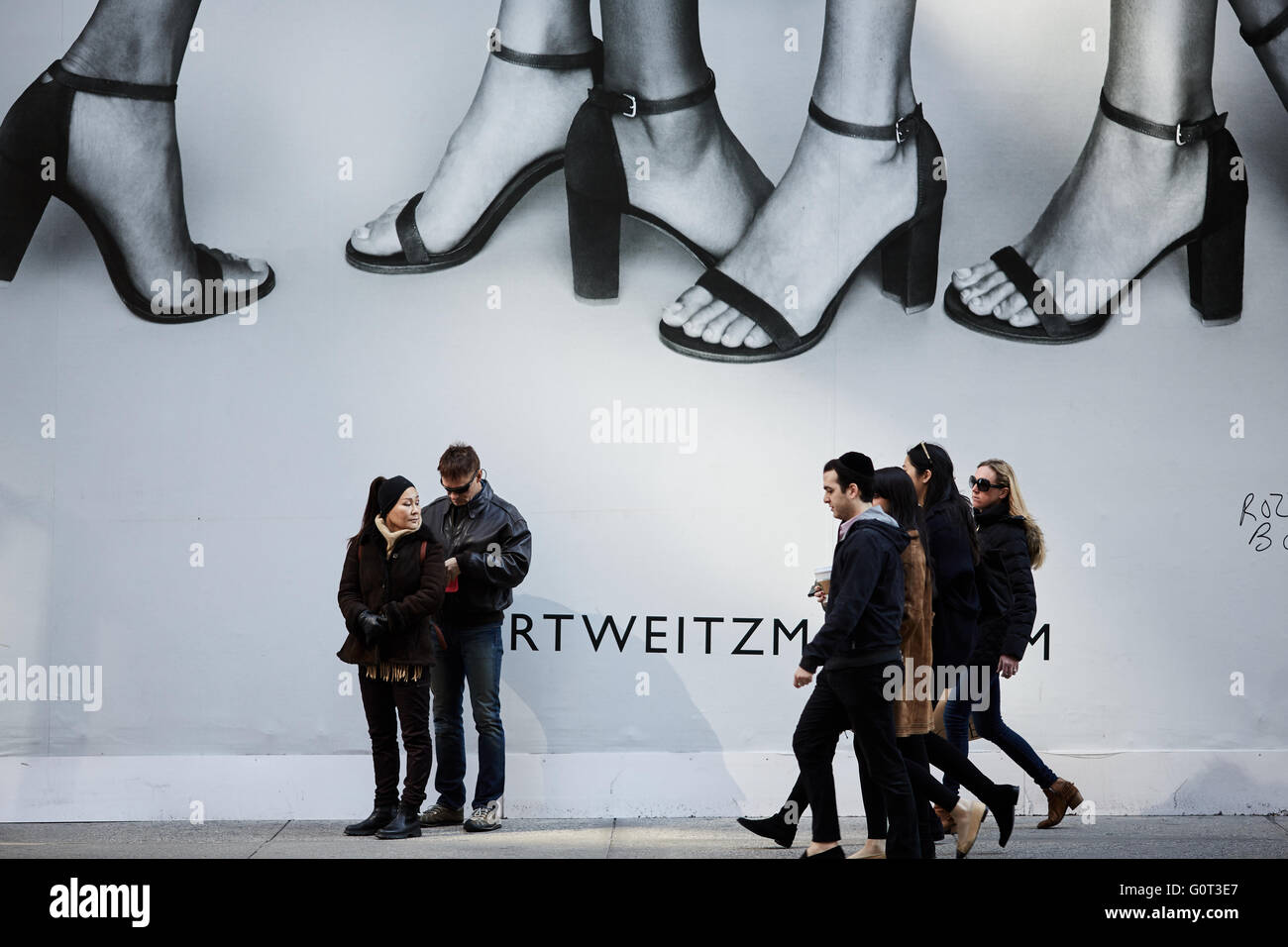 New york   Large oversized advert on 5th avenue covering shops people walking on sidewalk high heel feet shoes Stock Photo