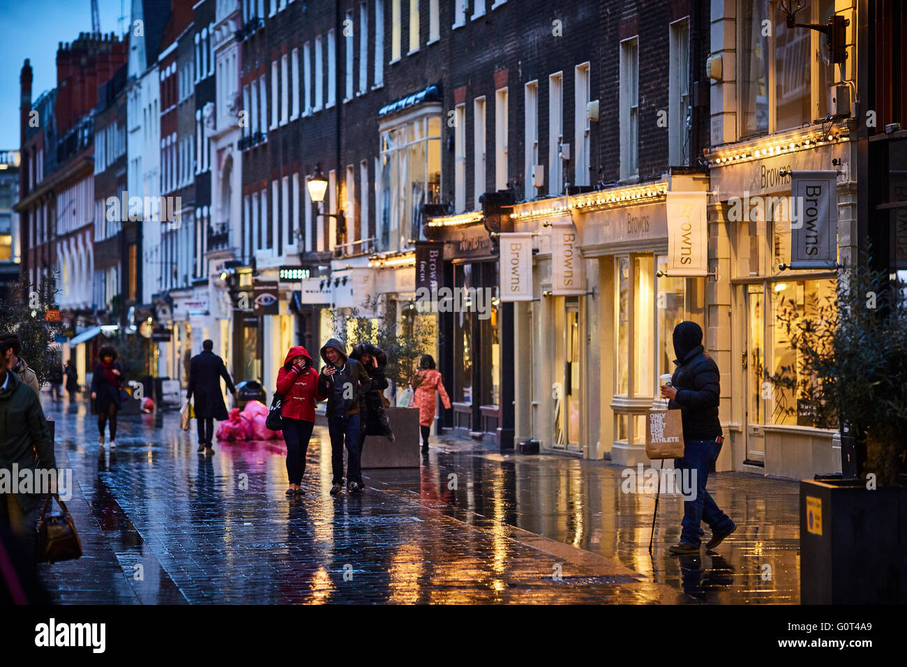 London street at  night and wet raining evening shopper walking Stock Photo