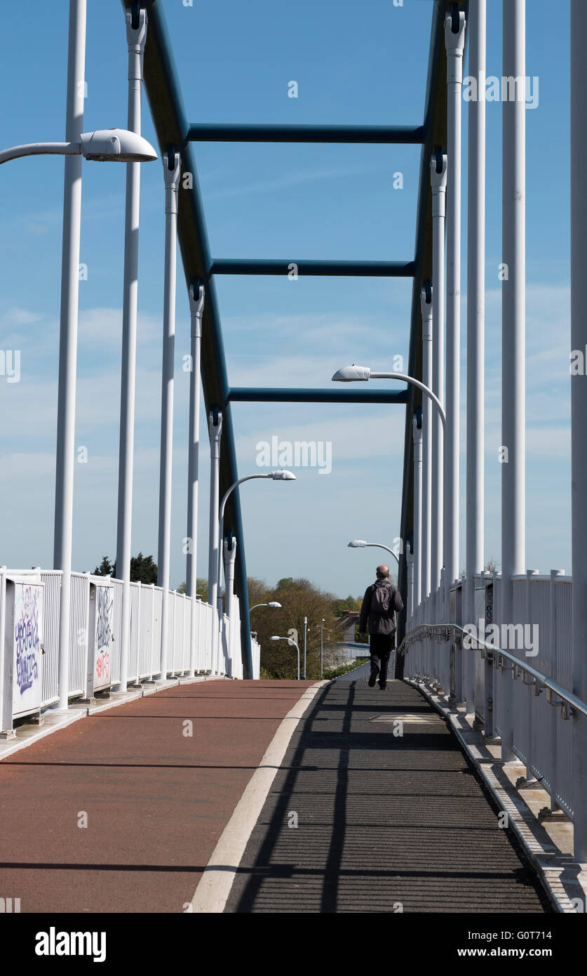 Walking crossing Jane Coston cycle bridge on warm sunny spring day Milton Cambridge England Stock Photo