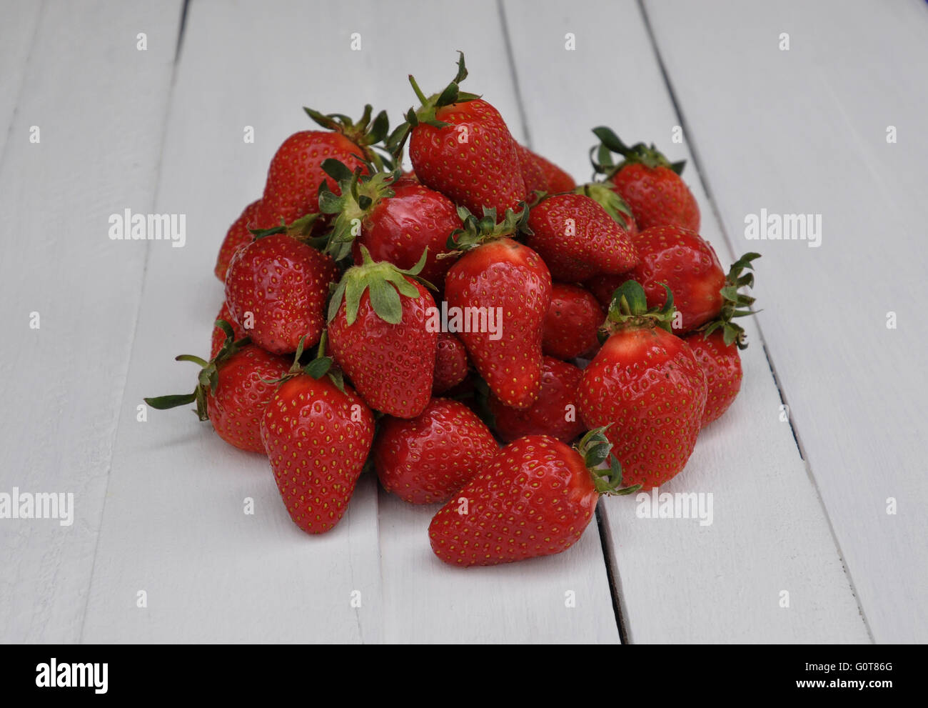 Ripe red strawberries on a white wooden table Stock Photo - Alamy