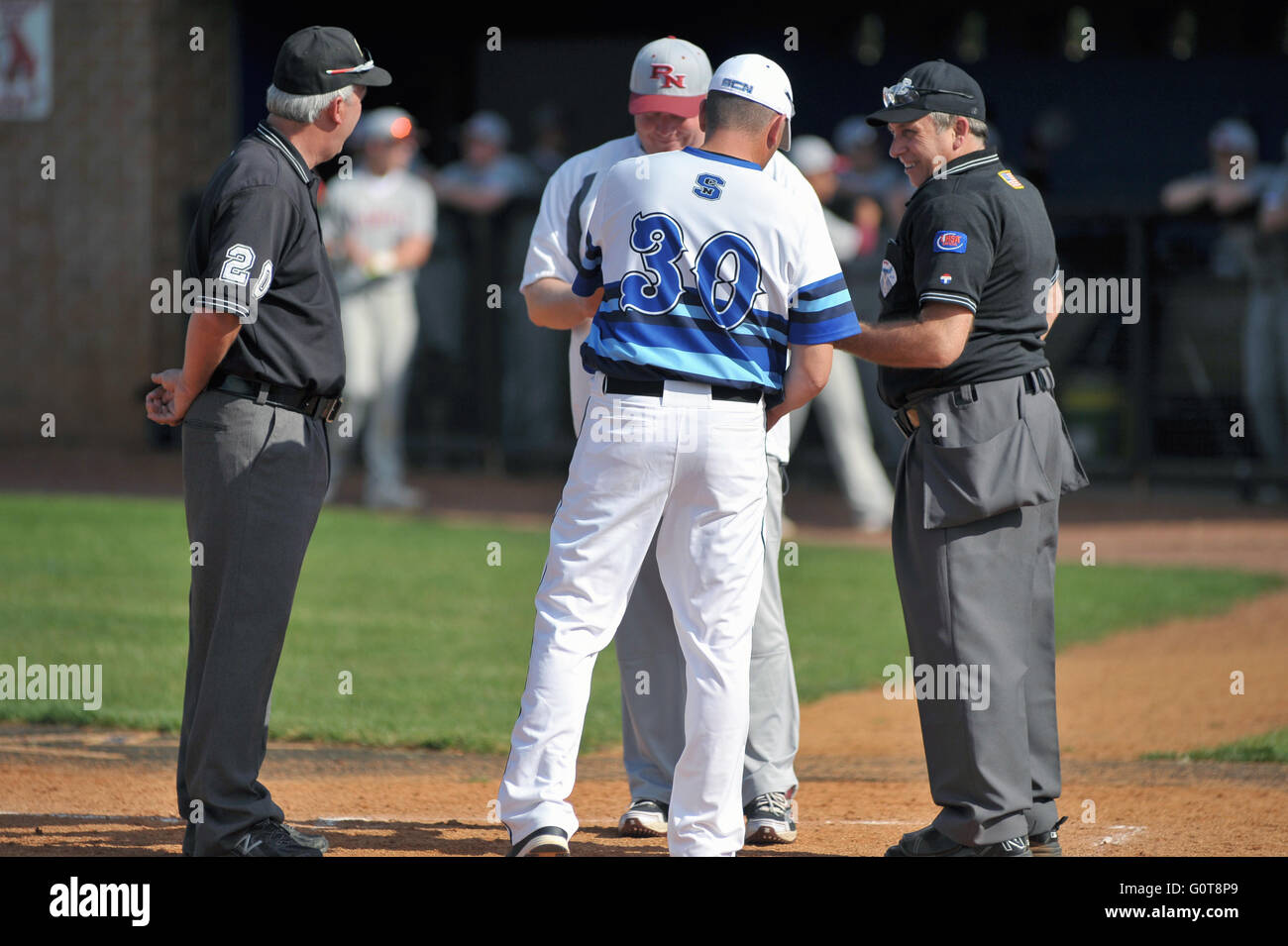 Umpires meet with head coaches to exchange lineup cards and go over ground rules prior to a high school baseball game. USA. Stock Photo