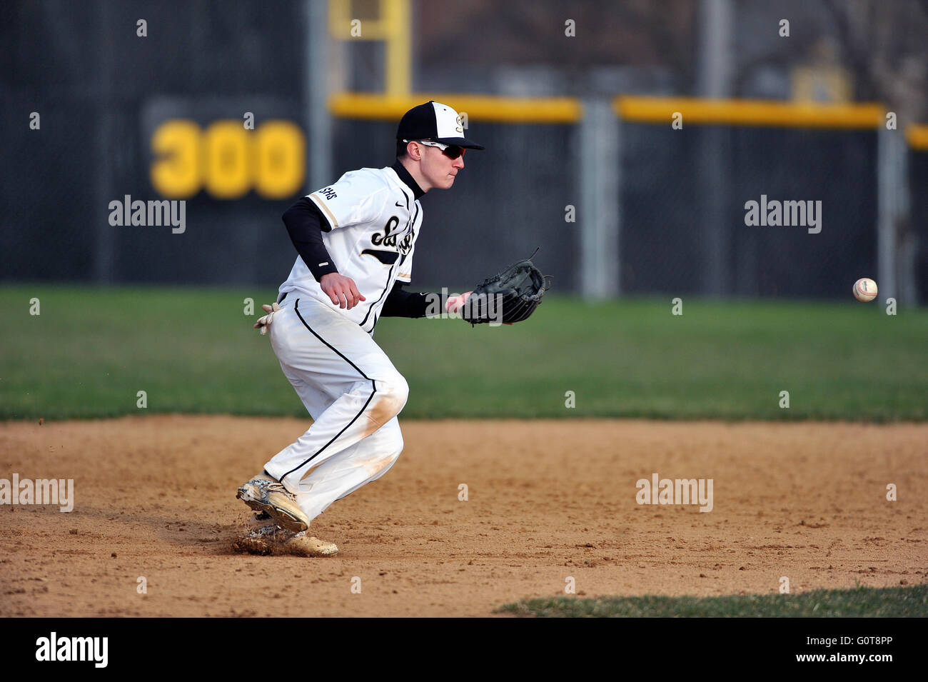 Second baseman lining up a ground ball behind second base during a high school baseball game. USA, Stock Photo