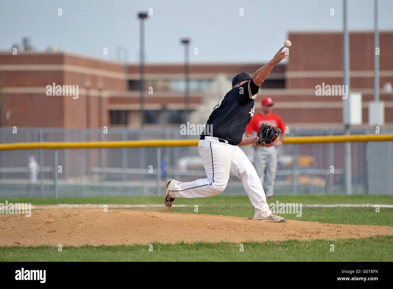 Righthanded pitcher delivering a pitch to a waiting hitter during a