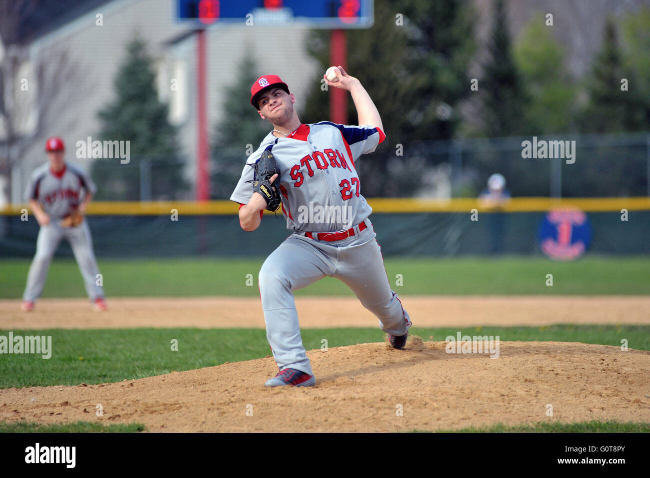 Lefthanded pitcher delivering a pitch to a waiting hitter during a