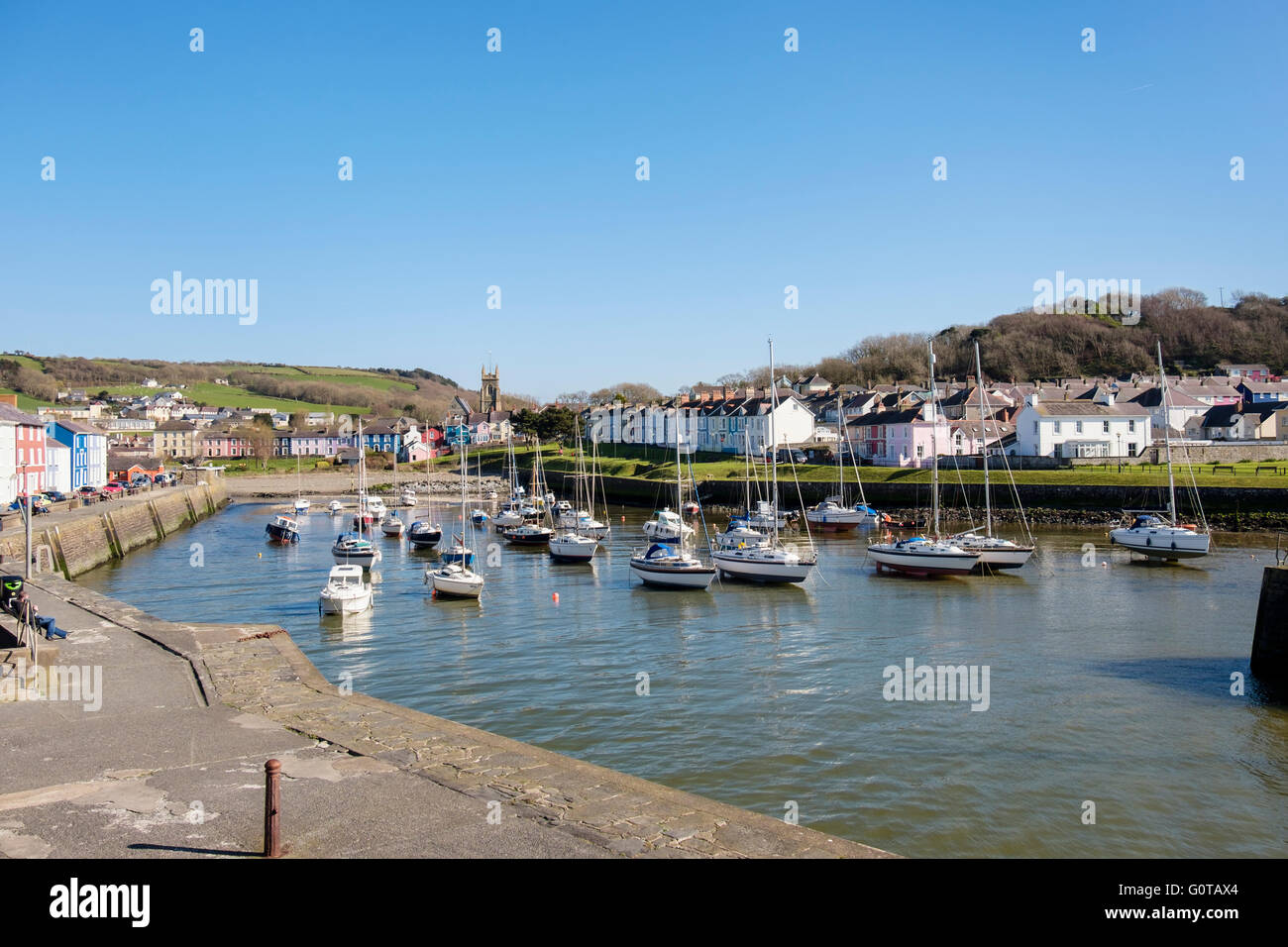 View along Afon Aeron River estuary with boats moored in harbour on incoming tide in pretty west town. Aberaeron Wales UK Stock Photo