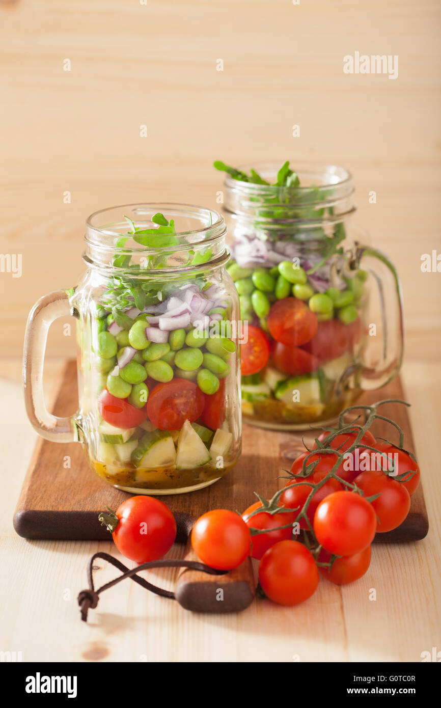 healthy vegetable salad in mason jar tomato, cucumber, soybean, onion