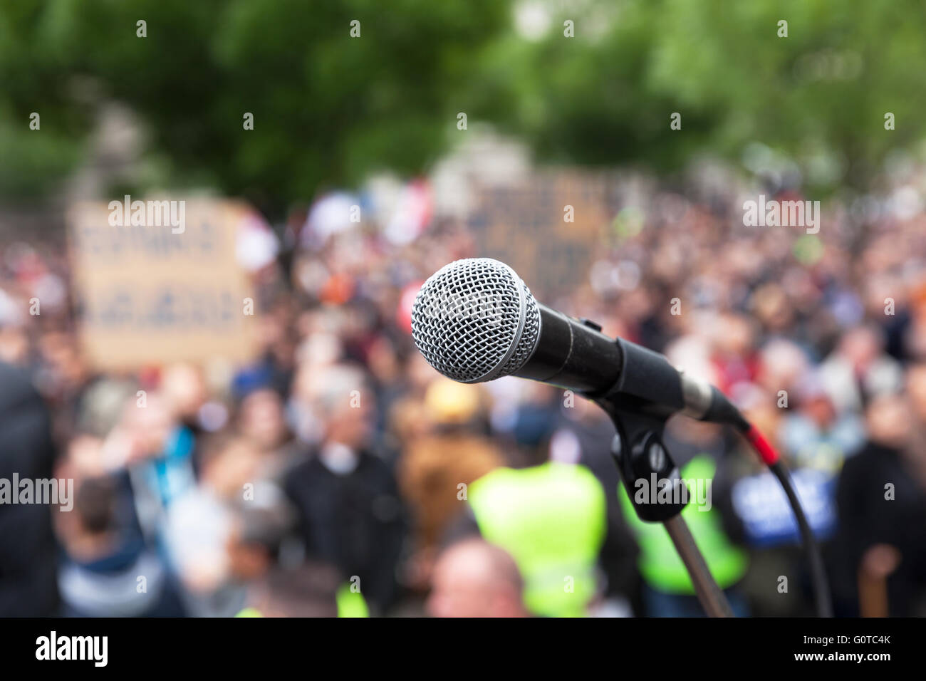 Microphone in focus against blurred crowd. Political rally. Stock Photo