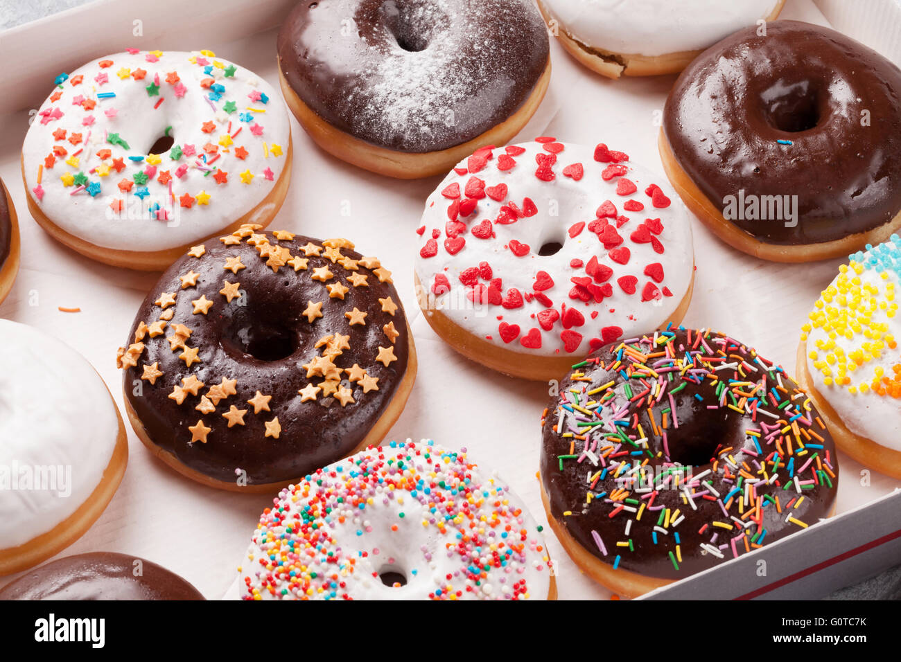Colorful donuts box on stone table Stock Photo - Alamy