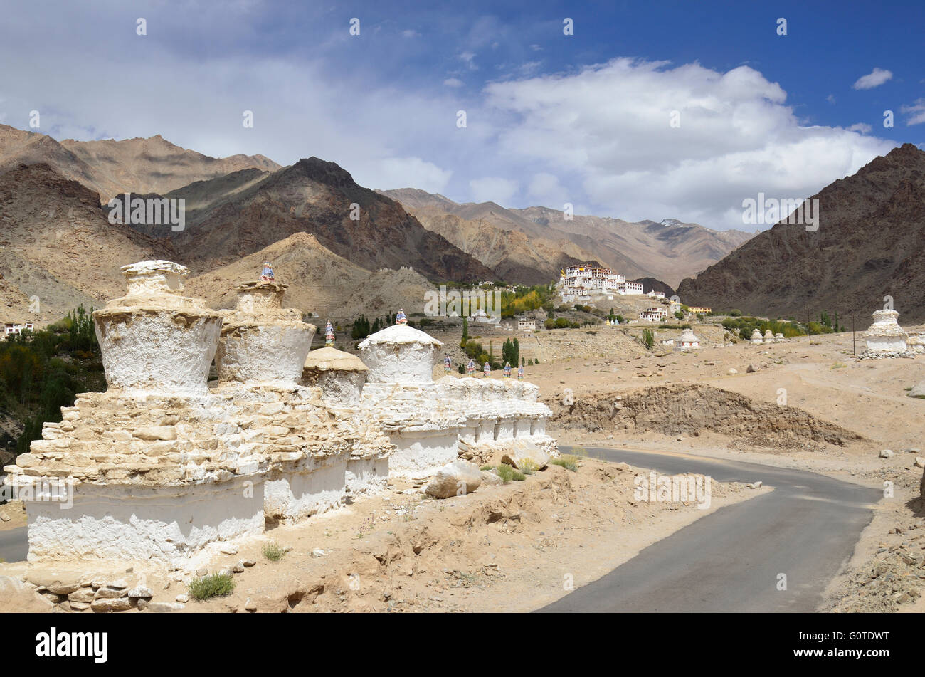 Buddhist Chortens in the foreground and Likir Monastery in the background, situated in a typical Ladakh landscape, near Leh, Ind Stock Photo