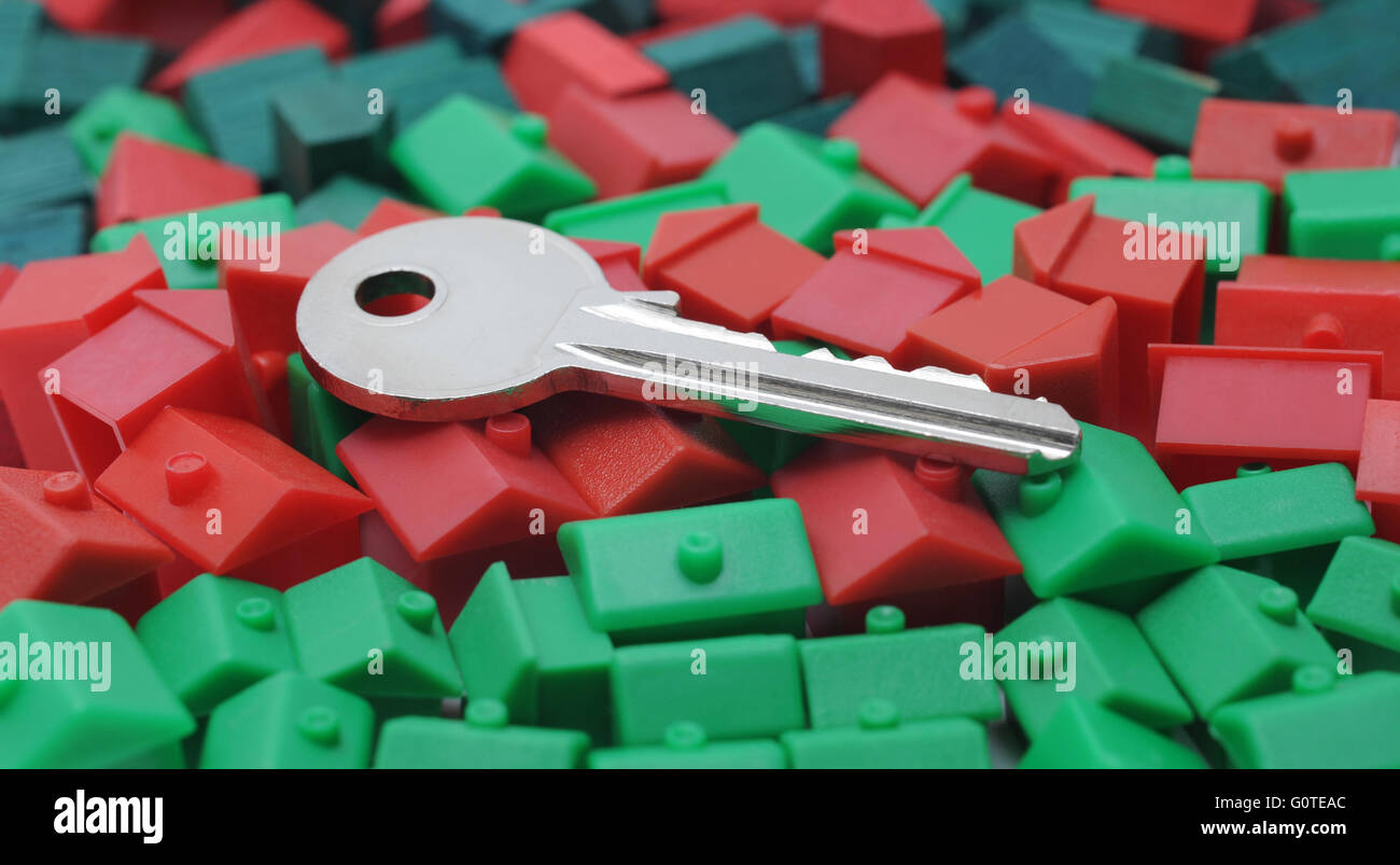 HOUSE KEY ON MODEL HOUSES RE HOUSING MARKET PROPERTY HOMES PRICES FIRST TIME BUYERS BUYING MONOPOLY  KEYS MORTGAGE RENTS RENT UK Stock Photo
