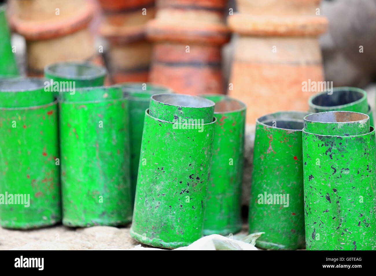 Green painted metal cylinders placed before a set of unidentified clay pottery-counter of shop in the Adi Haki market-Ethiopia. Stock Photo