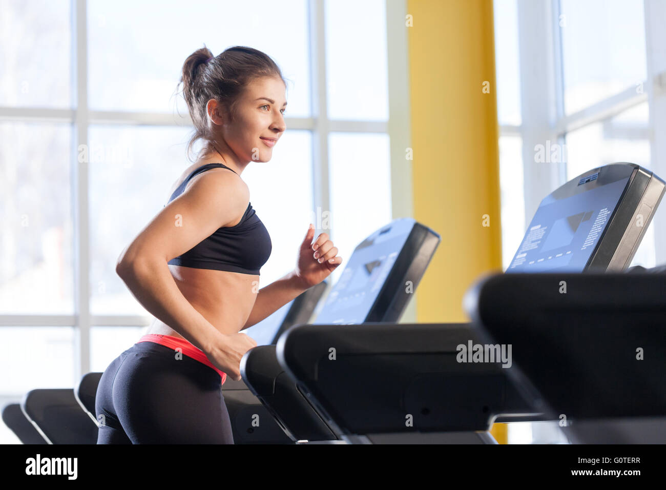 woman runs on a treadmill at the gym Stock Photo