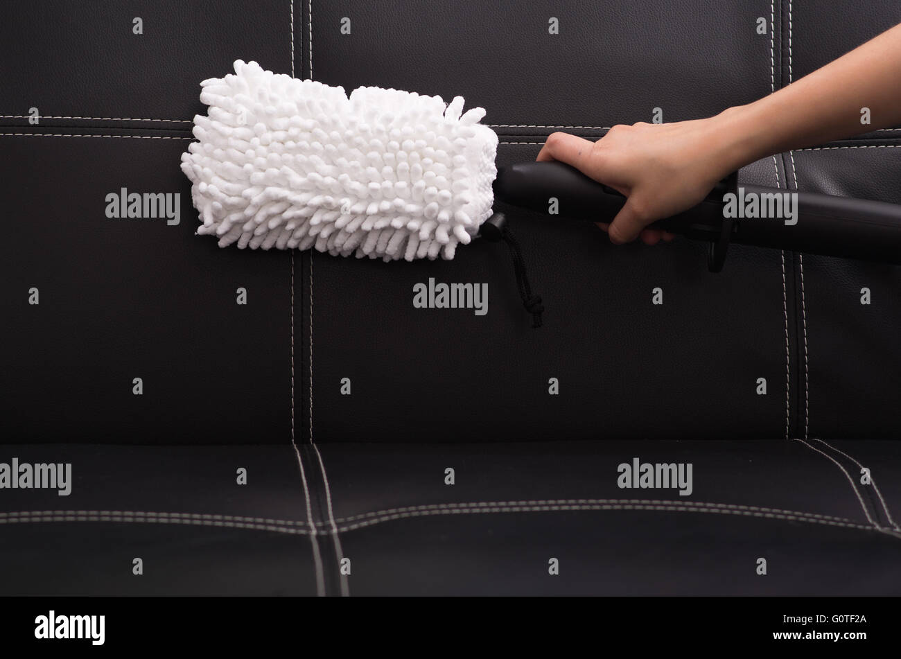 White fabric brush from steam cleaning machine being used on black