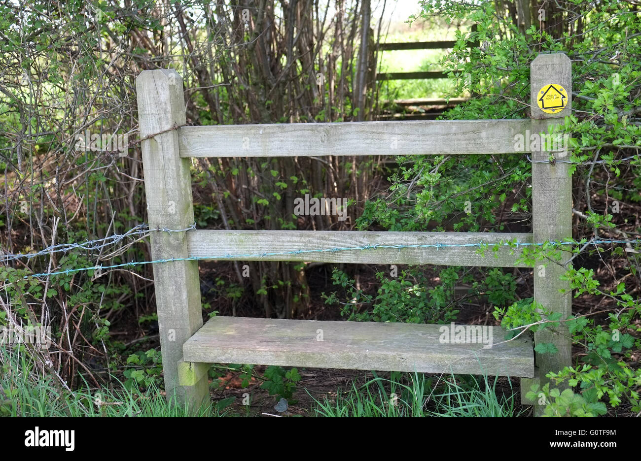 Stile on a British Public Footpath complete with yellow sign and barbed ...