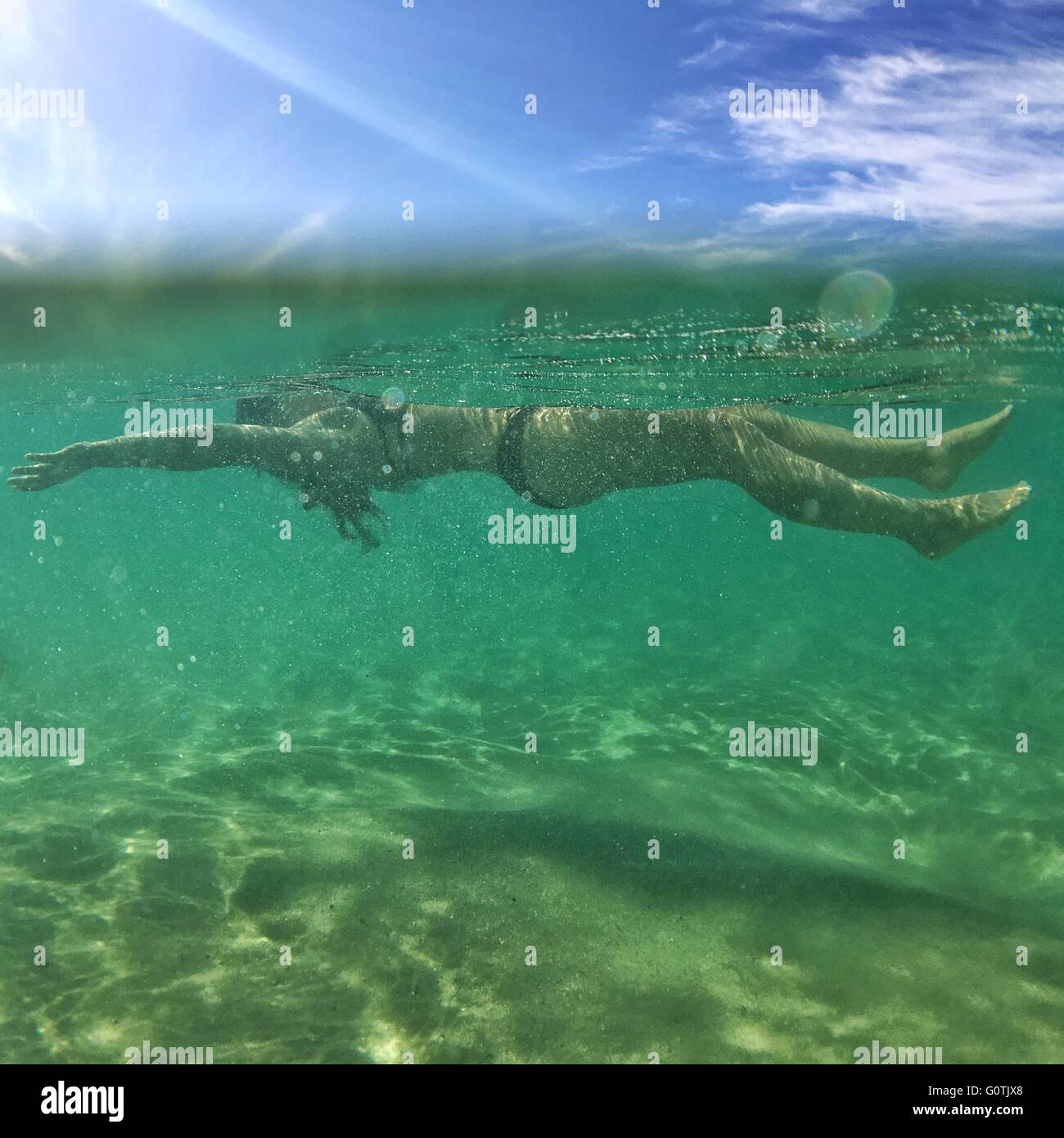 Woman floating in ocean Stock Photo