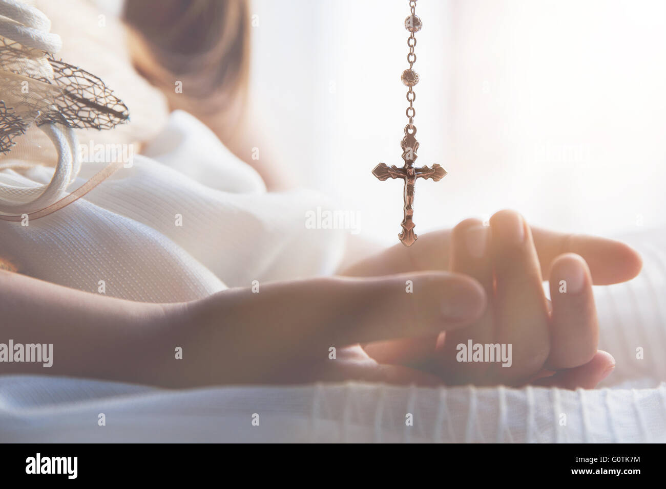 Girl holding a necklace with a crucifix Stock Photo