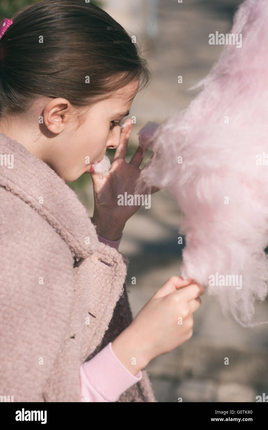 Side view of a girl eating cotton candy Stock Photo