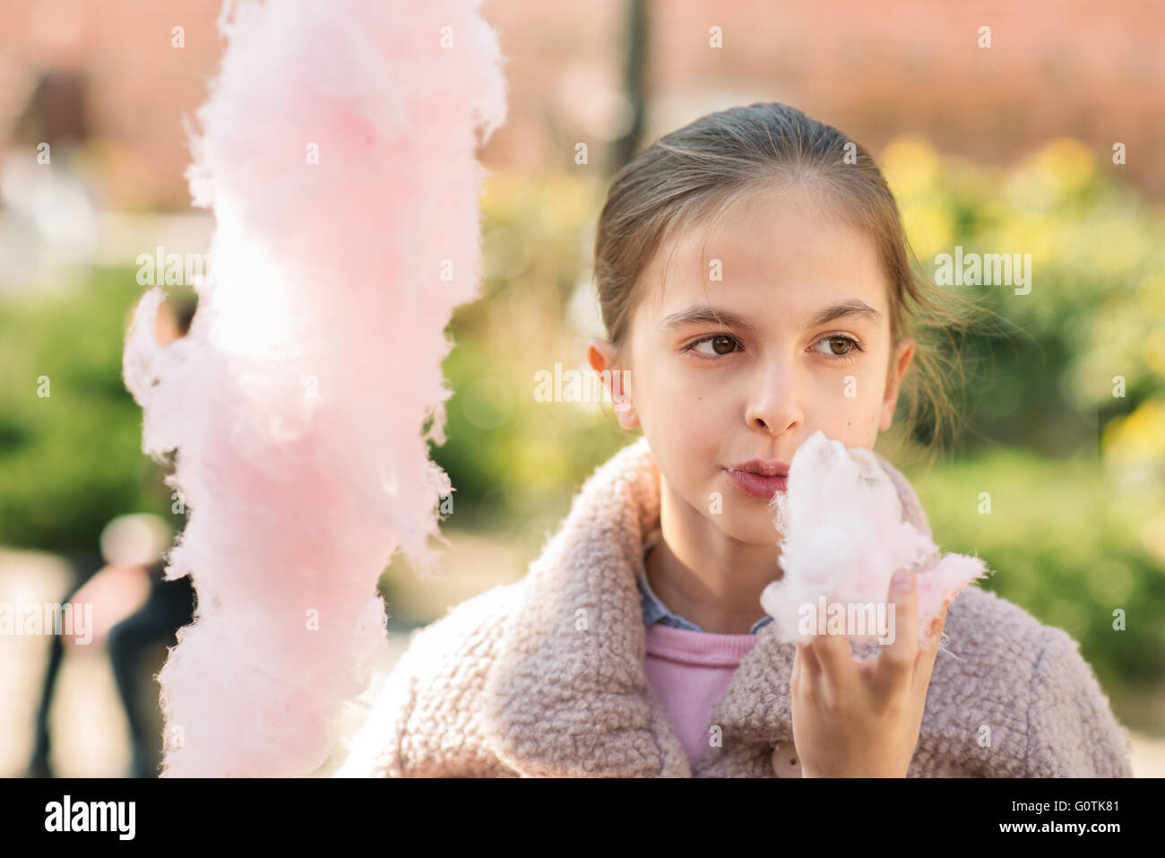 Front view of a girl eating cotton candy Stock Photo