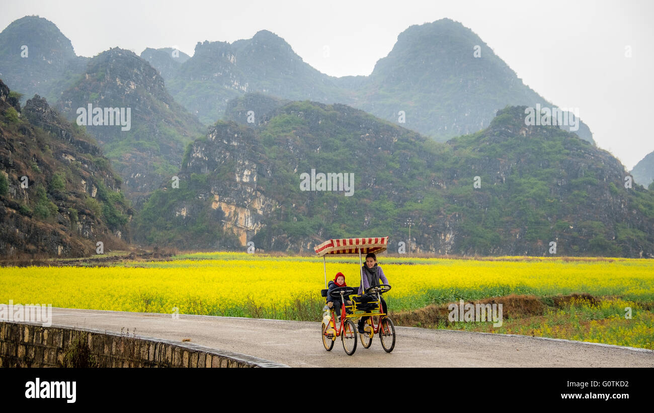 Mother and daughter cycling, Yunnan, China Stock Photo