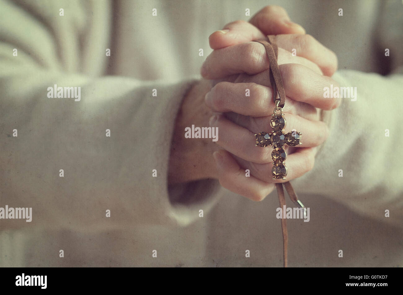 Senior woman with hands clasped holding a crucifix Stock Photo